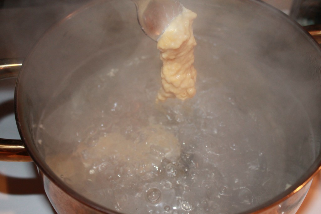 Drop dumpling dough by spoonful into boiling water.